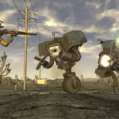 Gracz w kapeluszu strzela do robotów w pustynnym krajobrazie. To scena z najlepszej gry Fallout, pełnej akcji i postapokaliptycznych wyzwań.