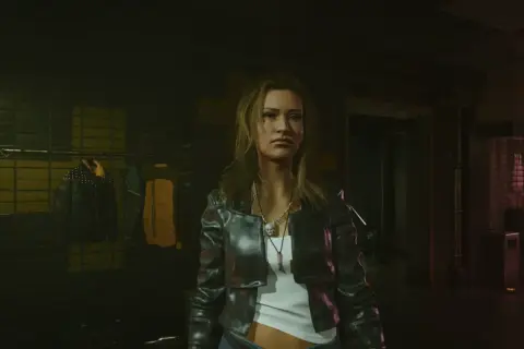 Kobieta w skórzanej kurtce, gotowa na nocne przygody w świecie cyberpunk romansów. W tle wieszaki z ubraniami.