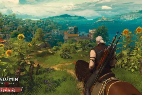 Geralt z Rivii, wiedźmin, przemierza konno malowniczą krainę pełną słoneczników, zmierzając ku miasteczku.