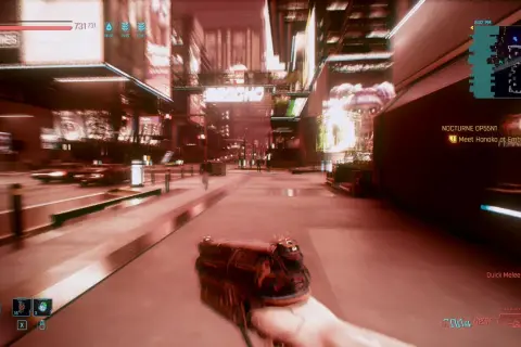 Wizja z gry Cyberpunk 2077, gdzie cyberpsychoza jest realnym zagrożeniem. Gracz trzyma broń, przemierzając neonowe ulice Night City.
