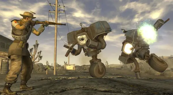 Gracz w kapeluszu strzela do robotów w pustynnym krajobrazie. To scena z najlepszej gry Fallout, pełnej akcji i postapokaliptycznych wyzwań.