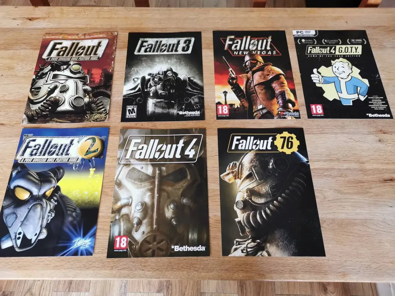 Kolekcja okładek gier z serii Fallout: Fallout, Fallout 2, Fallout 3, Fallout: New Vegas, Fallout 4, Fallout 4 G.O.T.Y. i Fallout 76.