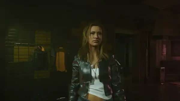 Kobieta w skórzanej kurtce, gotowa na nocne przygody w świecie cyberpunk romansów. W tle wieszaki z ubraniami.