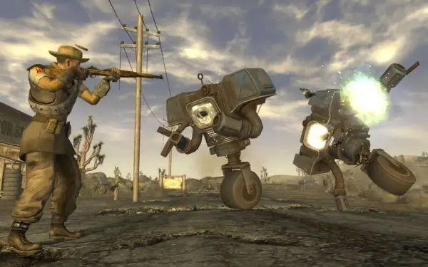 Gracz w kapeluszu strzela do robotów w pustynnym krajobrazie. To scena z najlepszej gry Fallout, pełnej akcji i postapokaliptycznych wyzwań.